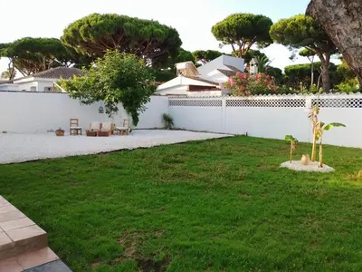 a backyard with a white fence and a grass yard at Casita Alejandro in Chiclana de la Frontera
