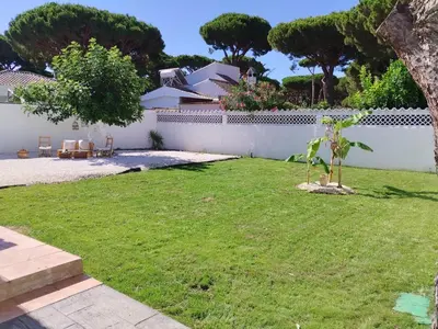a backyard with a white fence and a grass yard at Casita Alejandro in Chiclana de la Frontera