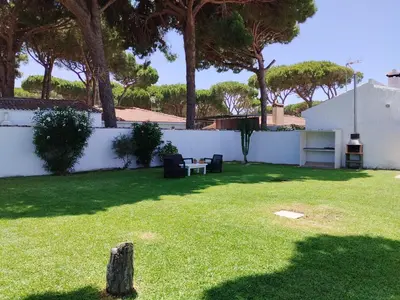 a yard with a white fence and a table and chairs at Villa Mencal in Chiclana de la Frontera