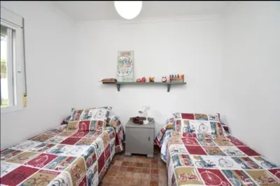 a bedroom with two beds and a shelf on the wall at Villa Mencal in Chiclana de la Frontera