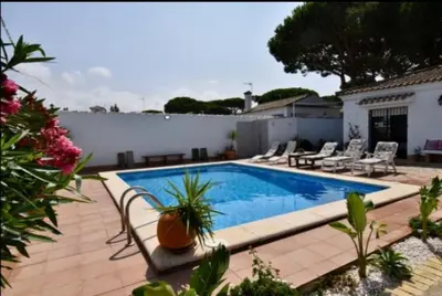 a swimming pool in the backyard of a house at Villa Mencal in Chiclana de la Frontera