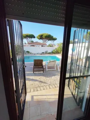a view of a pool from a sliding glass door at Villa Mencal in Chiclana de la Frontera