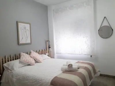 a bedroom with a bed with pink and white pillows at El Rincón del Mercado in Cádiz