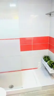 a white bathroom with red and white walls and a basket of plants at El Rincón del Mercado in Cádiz