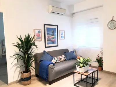 a living room with a couch and some plants at El Rincón del Mercado in Cádiz