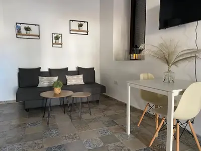 a living room with a couch and a table at Apartamentos Makao Puerta del Olivillo in Jerez de la Frontera