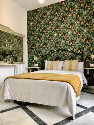 a bedroom with a large bed with a floral wallpaper at Apartamentos Makao Puerta del Olivillo in Jerez de la Frontera