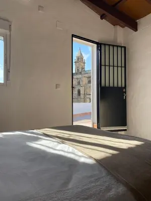 a room with a door with a view of a building at Apartamentos Makao Puerta del Olivillo in Jerez de la Frontera