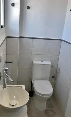 a bathroom with a white toilet and a sink at Apartamentos Makao Puerta del Olivillo in Jerez de la Frontera