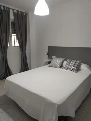 a large white bed in a room with a window at Mima in Cádiz