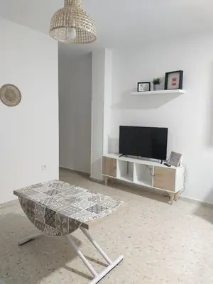 a living room with a table and a television at Mima in Cádiz