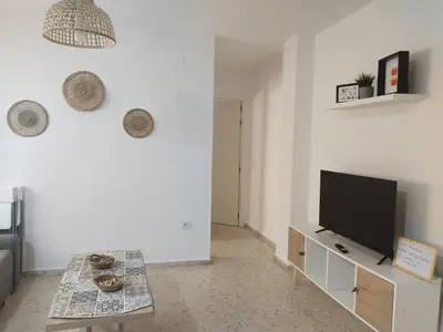 a living room with a flat screen tv on a white wall at Mima in Cádiz
