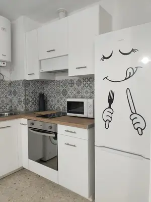 a kitchen with a drawing of a person holding a knife and fork at Mima in Cádiz