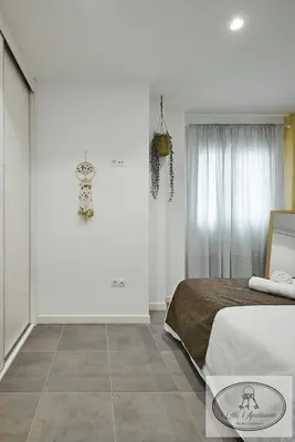 a bedroom with a bed and a tiled floor at Apartamento Playa Recreo Little Apartments in Cádiz