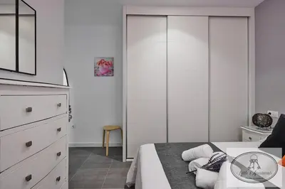 a white bedroom with a bed and a dresser at Apartamento Playa Recreo Little Apartments in Cádiz