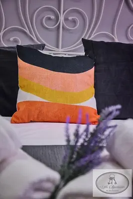 a colorful pillow on a bed with black and orange at Apartamento Playa Recreo Little Apartments in Cádiz