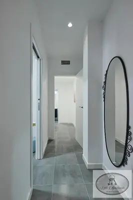 a hallway with a mirror and a tile floor at Apartamento Playa Recreo Little Apartments in Cádiz