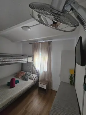 a bedroom with two bunk beds and a tv at Plaza de las Bodegas in El Puerto de Santa María