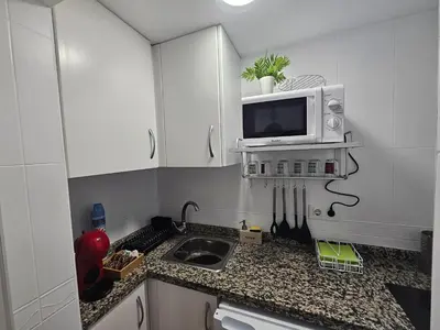 a small kitchen with a sink and a microwave at Plaza de las Bodegas in El Puerto de Santa María