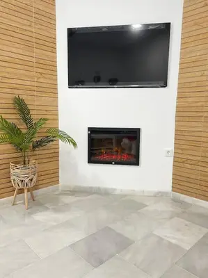 a living room with a fireplace with a flat screen tv at A menos d 1 min d plaza cabildo in Sanlúcar de Barrameda