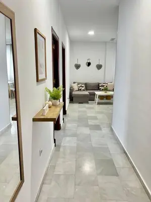 a hallway with a living room with a couch at A menos d 1 min d plaza cabildo in Sanlúcar de Barrameda