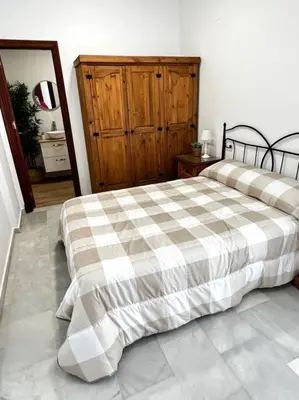 a bedroom with a bed with a checkered blanket at A menos d 1 min d plaza cabildo in Sanlúcar de Barrameda