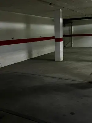 an empty parking garage with a red and white pole at A menos d 1 min d plaza cabildo in Sanlúcar de Barrameda