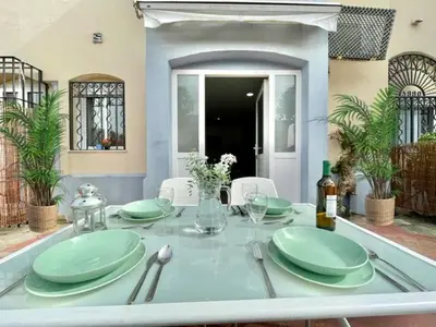 a table with green plates and silverware on it at GATU Sherry, junto puerto deportivo y playa in El Puerto de Santa María