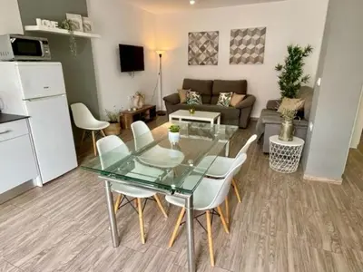 a living room with a glass table and white chairs at GATU Sherry, junto puerto deportivo y playa in El Puerto de Santa María
