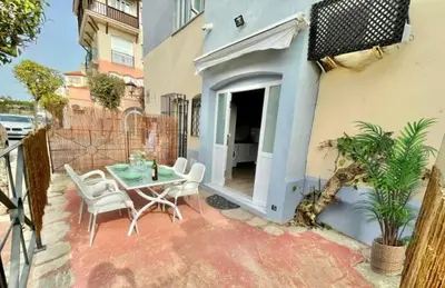 a patio with a table and chairs and a building at GATU Sherry, junto puerto deportivo y playa in El Puerto de Santa María