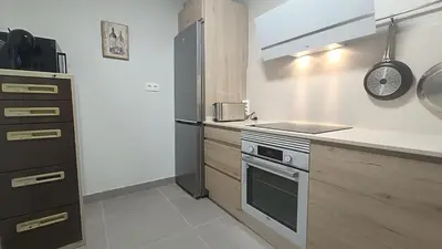 a kitchen with a stove and a refrigerator at Kiana Mirador Jerez con parking in Jerez de la Frontera
