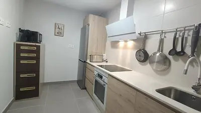 a kitchen with white cabinets and a sink and a stove at Kiana Mirador Jerez con parking in Jerez de la Frontera