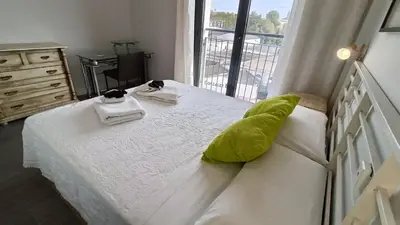 a bedroom with a bed with two towels and a window at Kiana Mirador Jerez con parking in Jerez de la Frontera
