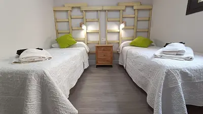 two beds in a room with green pillows at Kiana Mirador Jerez con parking in Jerez de la Frontera