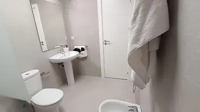 a white bathroom with a toilet and a sink at Kiana Mirador Jerez con parking in Jerez de la Frontera