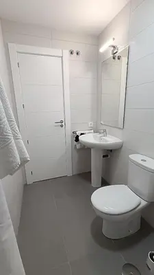 a white bathroom with a toilet and a sink at Kiana Mirador Jerez con parking in Jerez de la Frontera