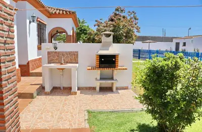 a backyard with an outdoor grill and a table at Chalet Florida III in Conil de la Frontera