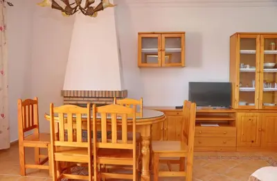 a dining room with a table and chairs and a television at Chalet Florida III in Conil de la Frontera
