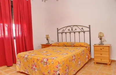 a bedroom with a bed and red curtains at Chalet Florida III in Conil de la Frontera
