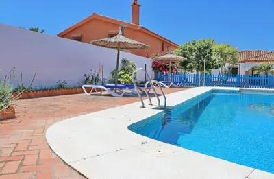 a swimming pool in front of a house at Chalet Florida III in Conil de la Frontera