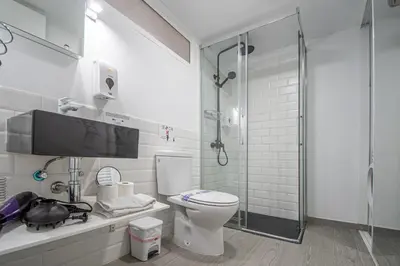 a bathroom with a toilet and a glass shower at Apartamento El Cobijo de Cádiz in Cádiz