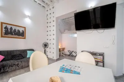 a living room with a table and chairs and a couch at Apartamento El Cobijo de Cádiz in Cádiz