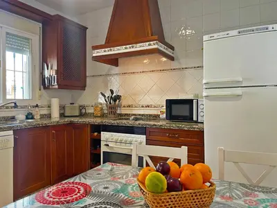 a kitchen with a table with a bowl of fruit on it at Casa Los Henke - Ole Solutions in El Puerto de Santa María
