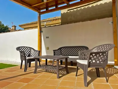 four chairs and a table on a patio at Casa Los Henke - Ole Solutions in El Puerto de Santa María