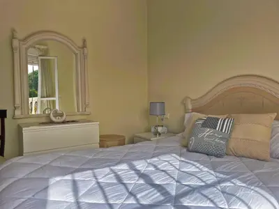 a bedroom with a large white bed with a large mirror at Casa Los Henke - Ole Solutions in El Puerto de Santa María