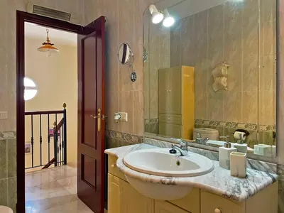 a bathroom with a sink and a mirror at Casa Los Henke - Ole Solutions in El Puerto de Santa María