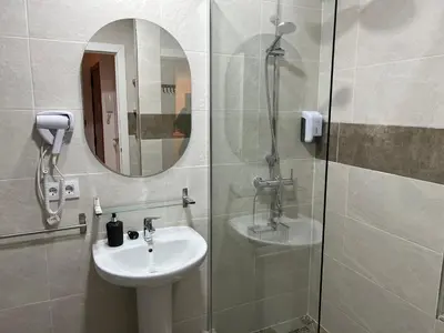 a bathroom with a sink and a shower with a mirror at Apartamento El Alquimista in Cádiz