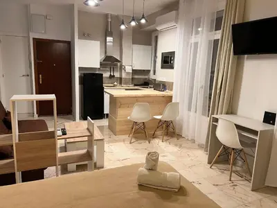a large kitchen and living room with white furniture at Apartamento El Alquimista in Cádiz