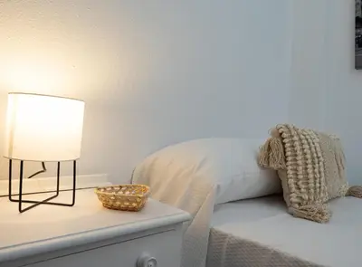 a bedroom with a bed and a lamp on a nightstand at Sibs Sanlucar-San Juan-Cabildo Centro Playa Familias Amigos in Sanlúcar de Barrameda