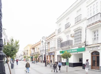 people walking down a street in a city with buildings at Sibs Sanlucar-San Juan-Cabildo Centro Playa Familias Amigos in Sanlúcar de Barrameda